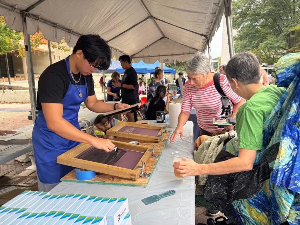 A young volunteer pulling a screen print